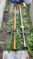 Two steel adjustable construction jacks full view