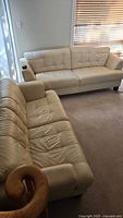 Both beige leather sofas in room