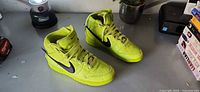 Pair of Nike x Ambush Dunk High Flash Lime sneakers angled view showing uppers and soles