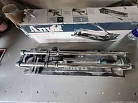 Anvil manual tile cutter on workbench with box