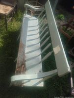 Top angled view of light blue spindle-back bench showing length and damaged seat area