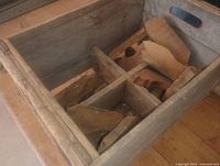 Wooden crate with internal dividers holding salvage wood pieces
