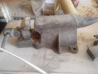 Left side view of cast iron combination vise showing jaws, screw handle, and anvil horn