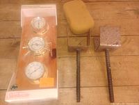 Boxed Sunbeam weather station with three gauges, two steel concrete brackets with rebar, yellow sponge on wooden surface