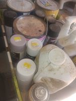 Top view of box showing multiple gallon paint cans, aerosol cans, spray bottles and large jug