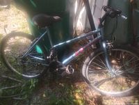 Left side view of metallic blue mountain bike showing frame, wheels, drivetrain, and suspension