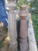 Two wooden newel posts standing side by side showing design details