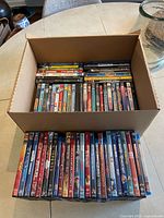 Open box with rows of DVDs and Blu-rays plus additional row placed in front