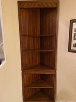 Full view of the wooden corner shelf unit showing all shelves and two-section design