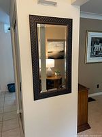 Full view of rectangular metal-framed mirror mounted on wall