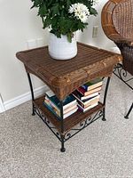 Full view of wicker and metal side table with vase and books (contents not included)