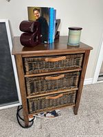 Front view of Pier 1 wood side table with three wicker drawers