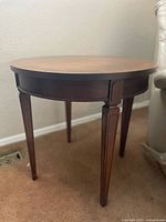 Full view of round side table showing legs and finish