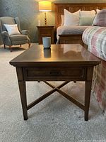 Angle view of side table showing top, drawer, legs and stretcher