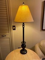Full view of illuminated metal table lamp on table