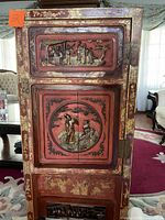 Front view showing carved and gilded panels and overall cabinet structure