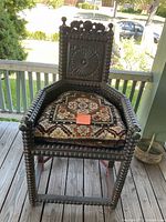 Front view of antique spool-turned armchair with cushion