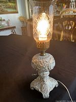Lamp lit showing glass shade pattern and ornate base