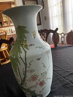 Front view of porcelain vase showing painted birds, bamboo and blossoms