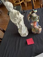 Front view of both figurines on table with scale reference