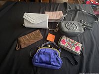 All seven purses arranged on table showing variety of styles and colours
