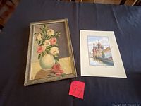 Framed floral oil painting and unframed cathedral print displayed side by side