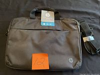 Front view of HP laptop bag with tag and shoulder strap