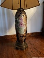 Close view of porcelain body detailing rose panel and gilt leaves