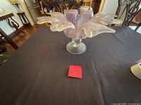 Vase side view on table showing flower-shaped ruffled rim and pedestal