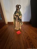 Front view of painted religious statue holding crook