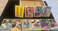 Wide view showing card storage box with full stack of cards, front checklist and nine sample 1985 O-Pee-Chee baseball cards displayed
