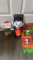Group showing three plush toys, Snoopy sweater, waste bag rolls and Halloween cloth