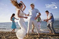 Group of people dancing on a beach with Arthur Murray logo visible, representing dance lifestyle