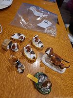 All items laid on table: five basket hounds, sweater hound, mother with pups, Limoges box