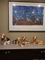 Group view of six Basset Hound figurines on cabinet