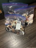 Three zip bags filled with assorted small dog figurines
