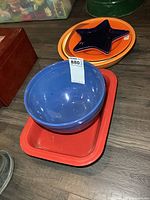 Blue mixing bowl inside red rectangular baker with lot tag visible