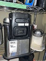 Stainless steel appliance with black top likely T-Fal deep fryer, partial view of white drink master at right