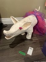 Full view of paper mache pig with tutu, green dimension tag visible