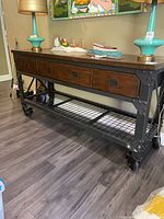 Full view of sideboard showing top, drawers, lower shelf and casters