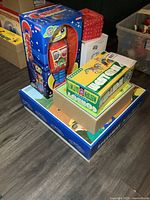 Stack of four boxed tin toys