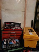 Red metal tool chest with Husky socket set, yellow Rubbermaid toolbox, Bernzomatic torch kit box