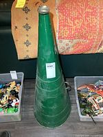 Full view of green metal megaphone standing upright