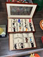 Open watch case showing upper tier with 12 watches and ring slots