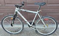 Full left side view of silver Raleigh Summit mountain bike