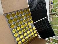 Open box showing multiple gold-lidded jars and label sheets