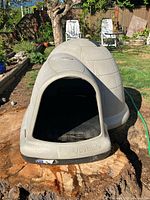 Front view of large Petmate igloo dog house on stump