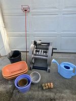 Group shot showing all items including hose reel, pots, watering can, candle stake, pot feet