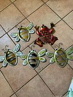 front view of four bee ornaments and frog ornament
