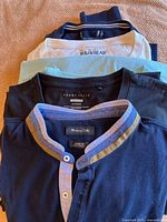 Stack showing Mossimo Dutti henley, Perry Ellis tee, IZOD aqua tee, Pull&Bear tee
